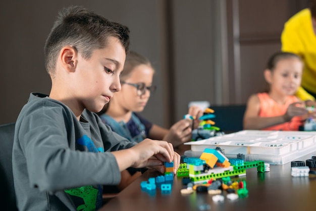 Kids creating robots with teacher.