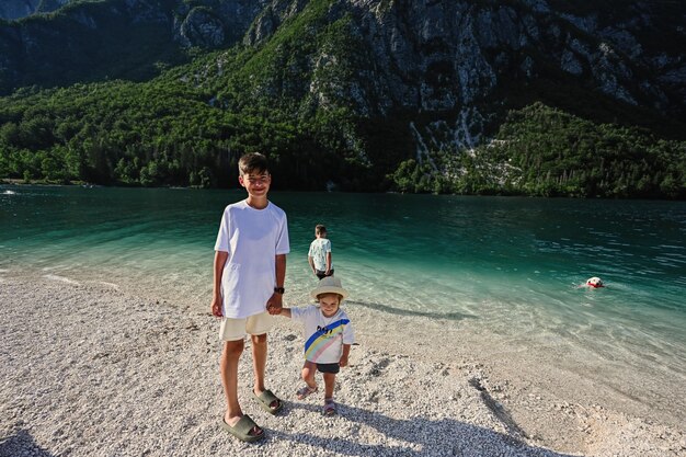 Kids and dog in Lake Bohinj the largest lake in Slovenia part of Triglav National Park