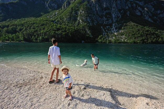 Kids and dog in Lake Bohinj the largest lake in Slovenia part of Triglav National Park