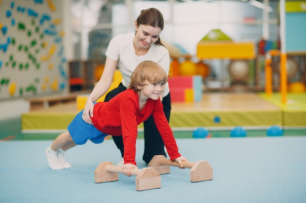 Kids doing exercises push up in gym at kindergarten or elementary school. Children sport and fitness concept.