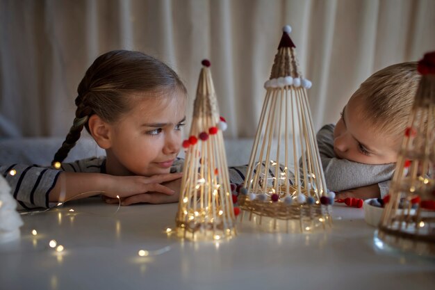 Дети мечтают возле поделки новогодней елки из бамбуковых палочек многоразовое украшение своими руками новогоднее украшение
