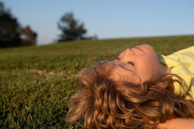 Kids dreaming child boy enjoying on grass field and dreaming kids play on summer field