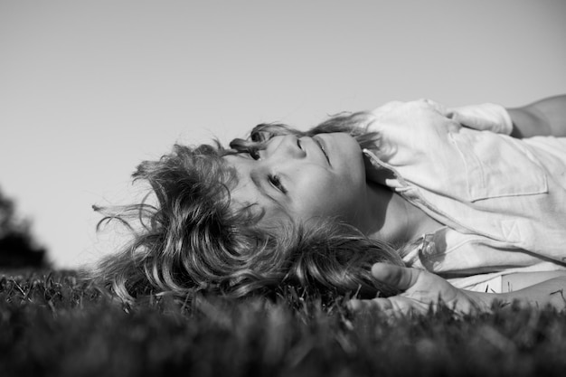 Kids dreaming happy little boy laying on grass kids exploring nature summertime