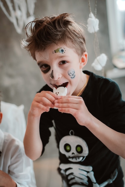 Kids eat Halloween sweets at a costume party