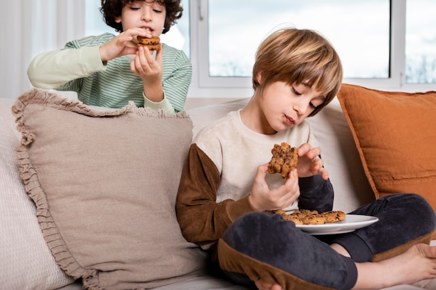 家でクッキーを食べる子供たち