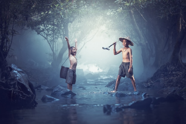 Kids enjoyed fishing in creeks,two boys happy and smile ,Thailand