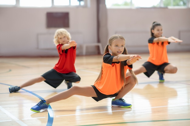 kids exercising in the gym and looking concentrated