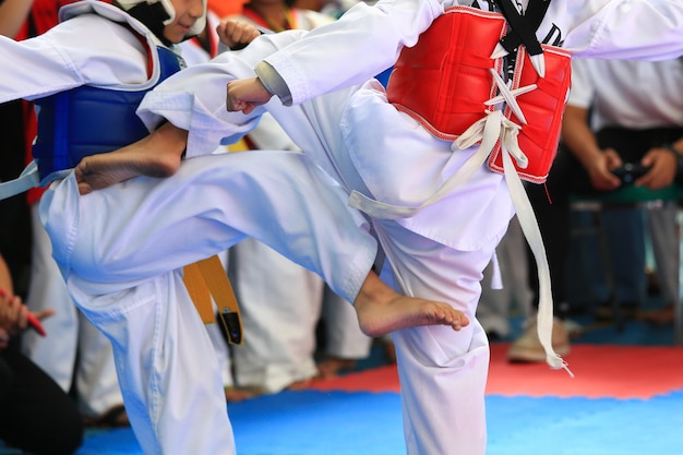 Photo kids fighting on stage during taekwondo tournament