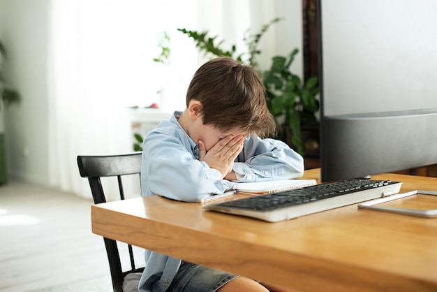 Kids and gadgets. Distance learning during isolation during quarantine. Boy and laptop at home. Lifestyle. Lockdown and Social Distancing