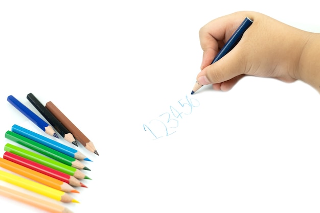 Kids hand with pencil writing English words by hand on  white notepad paper