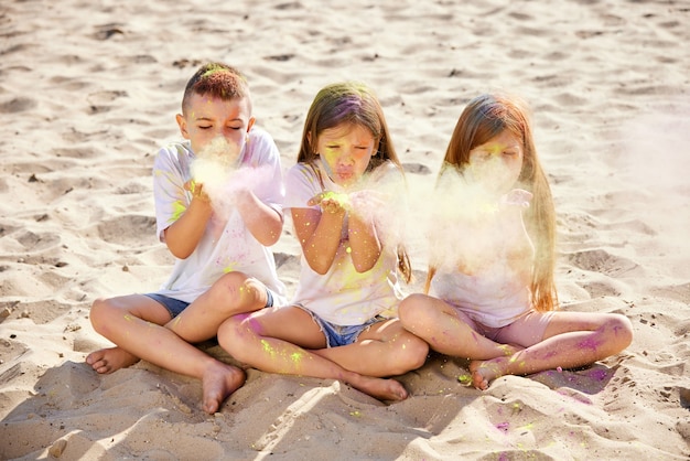 Foto i bambini si divertono giocando con la polvere colorata