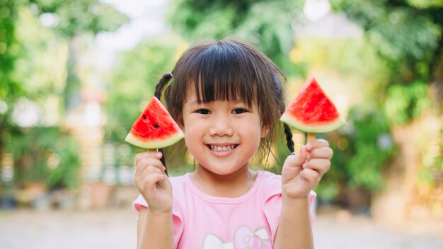 子供たちが楽しんで、スイカを食べることによって暑い夏の休日を祝う