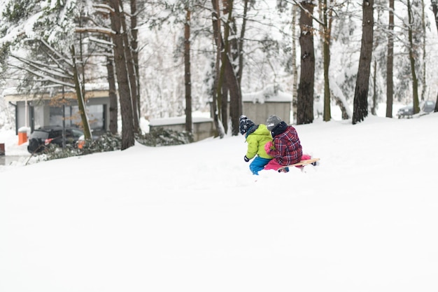 Photo kids having fun on sledding playing in snow