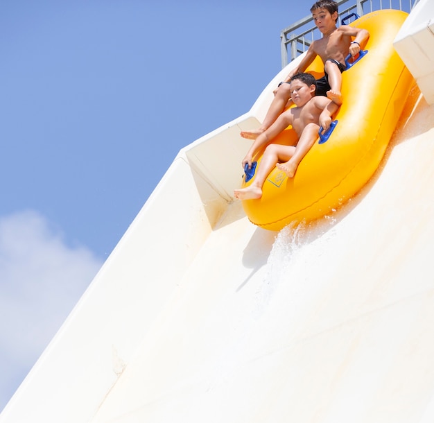 kids having fun sliding in water park