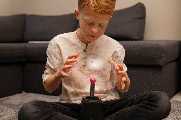 Foto bambini che interagiscono con una palla al plasma