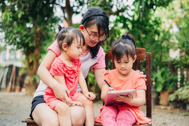 I bambini imparano a leggere e scrivere con sua madre usando il tablet.