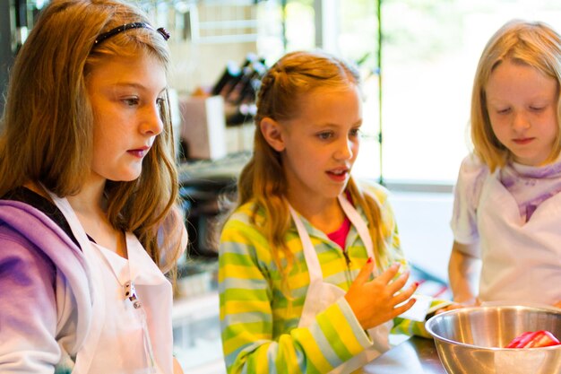 Kids learning how to cook in a cooking class.