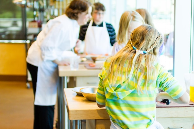 Kids learning how to cook in a cooking class.