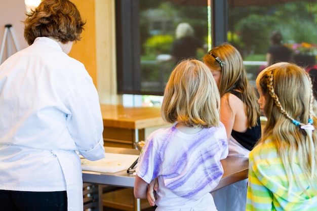 Kids learning how to cook in a cooking class.