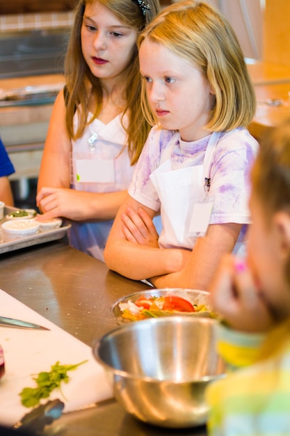 Kids learning how to cook in a cooking class.