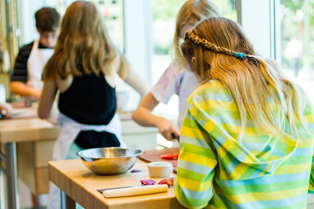 Kids learning how to cook in a cooking class.