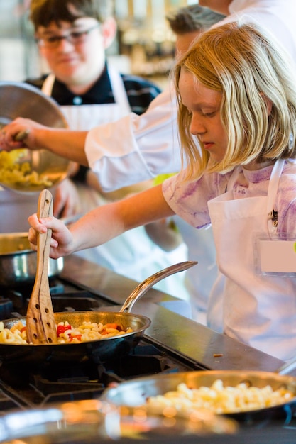 Kids learning how to cook in a cooking class.