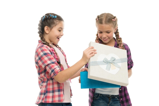 머리띠 헤어스타일을 한 어린 소녀들은 선물 상자를 들고 있습니다. 선물 포장을 풀면서 신나는 아이들. 작고 귀여운 소녀 자매들이 명절 선물을 받았습니다. 꿈은 이루어진다. 최고의 생일 및 크리스마스 선물.
