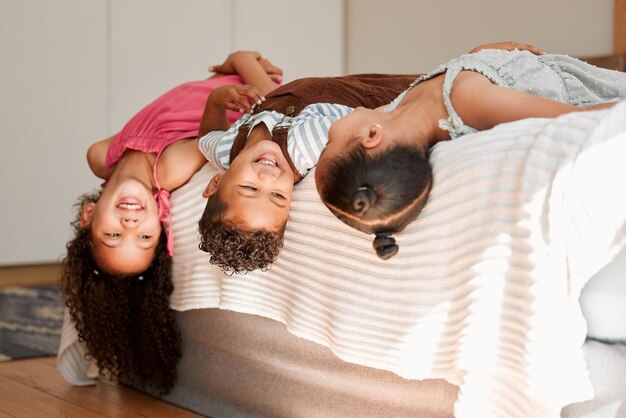 Kids lying on bed playful fun and silly generation with cute hairstyle and smiling portrait Relaxing playing indoors showing growth child development and childhood innocence from little siblings