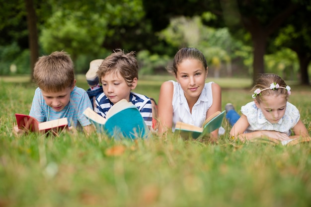 Kids lying on grass and reading books