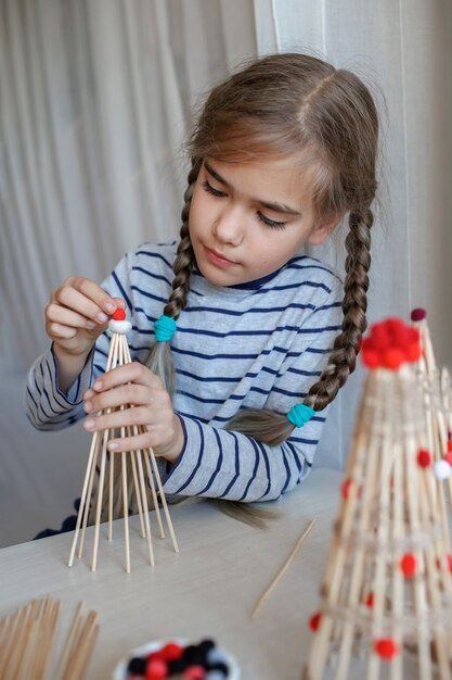 아이들은 대나무 막대기로 만든 크리스마스 트리를 재사용 가능한 장식 diy 새해 장식으로 만듭니다.
