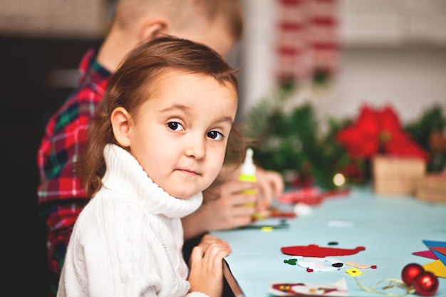 Kids making decor for Christmas tree or gifts. Christmas handmade diy project.