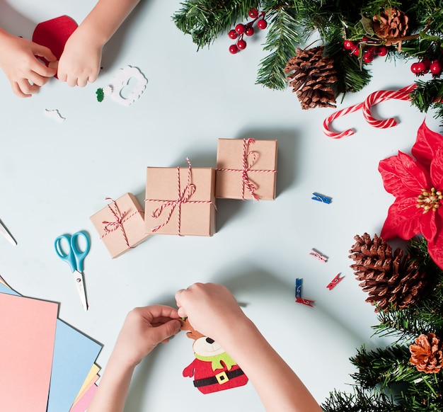 Bambini che fanno decorazioni per albero di natale o regali.