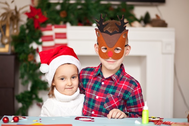 Kids making decor for Christmas tree or gifts.