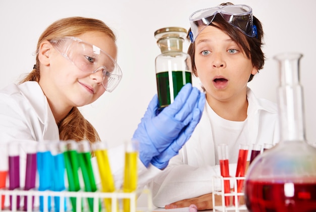 Kids making experiments in chemical laboratory