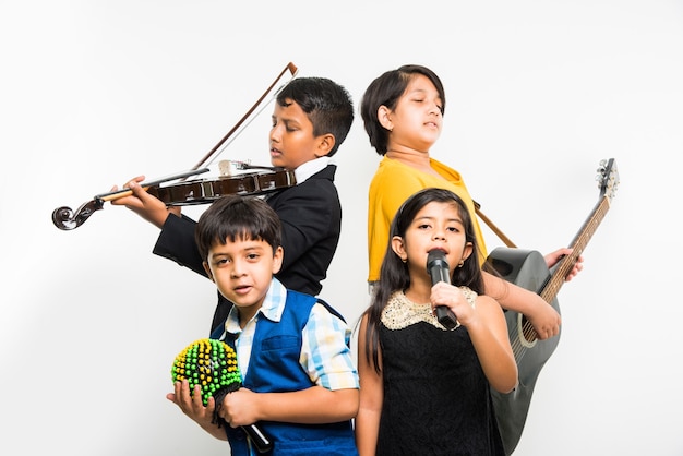 어린이와 음악 개념 - 흰색 배경 위에 팀이나 밴드로 악기를 연주하는 귀여운 인도 아이들