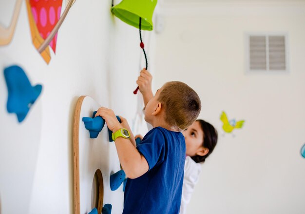 Photo the kids play a dexterity game are climbing a wall