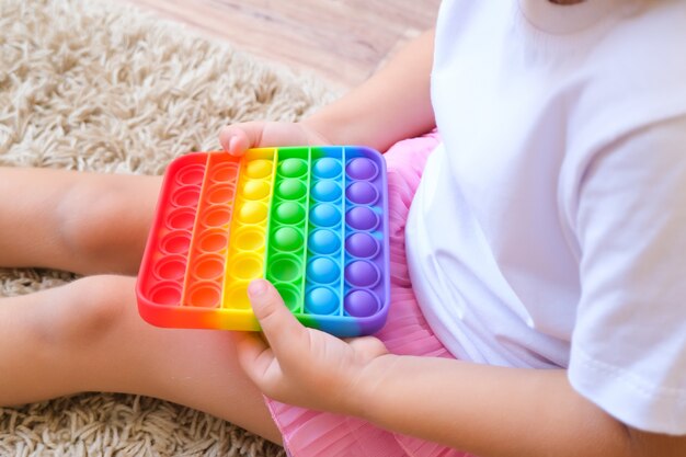 I bambini giocano con il giocattolo sensoriale pop it. sollievo dallo stress e dall'ansia. gioco di agitazione in silicone alla moda per bambini e adulti stressati. morbidi giocattoli a bolle d'aria.