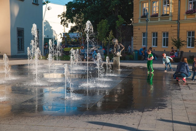 Bambini che giocano nella piazza della città vicino alla fontana