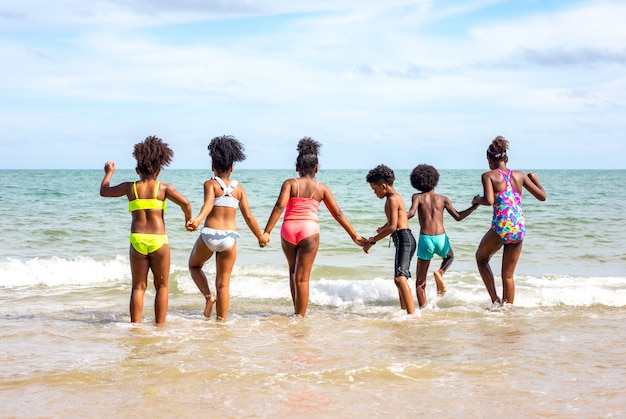 Kids playing running on sand at the beach