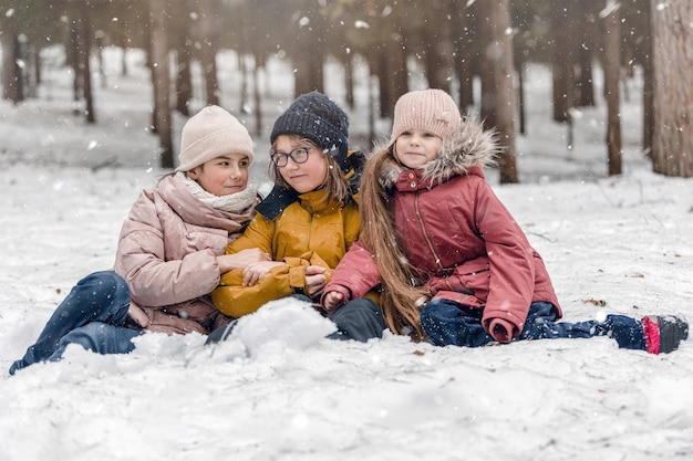 Kids playing in snow Children play outdoors in winter snowfall