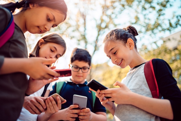 Kids playing video games on smart phone after school