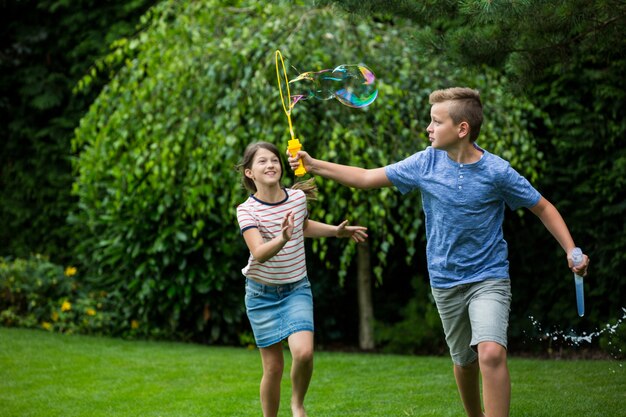 Kids playing with bubbles in the park