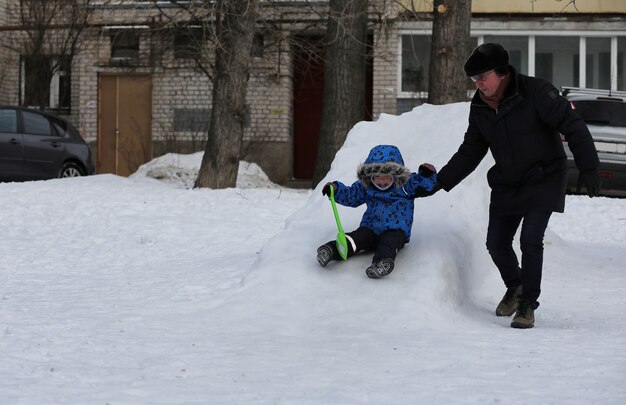 街の裏庭で冬に雪で遊ぶ子供たち