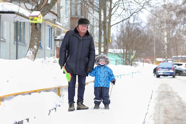 Дети играют со снегом зимой на заднем дворе в городе