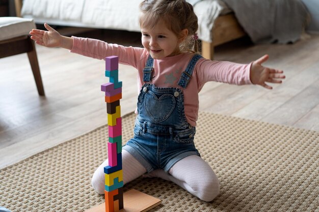 Foto bambini che giocano con blocchi di legno sul pavimento della loro stanza