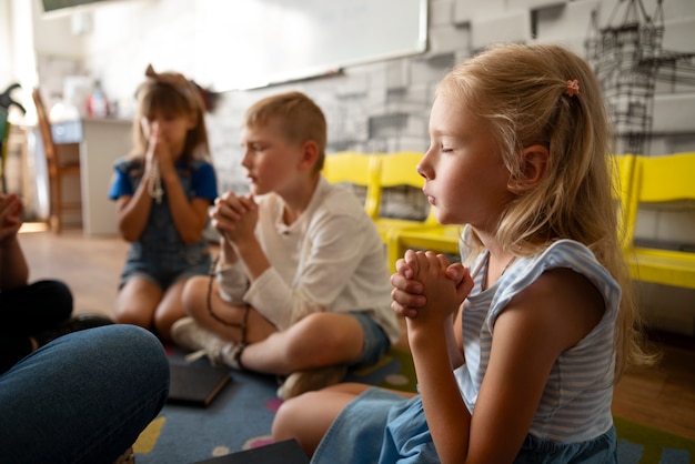 日曜学校の側面図で祈る子供たち