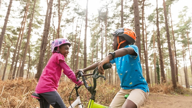 Bambini in sella alla loro bicicletta nei boschi