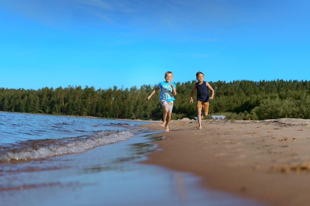 Kids running alone esa side Pine forest on background Happy childhood concept