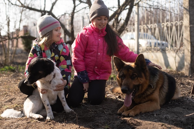 Kids running with their pet German shepherd puppy in the park