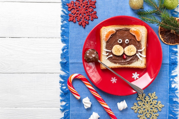 Sandwich per bambini a forma di tigre fatta di frutta fresca e cioccolato su un piatto con spazio per le copie. capodanno, cibo di natale. vista dall'alto.